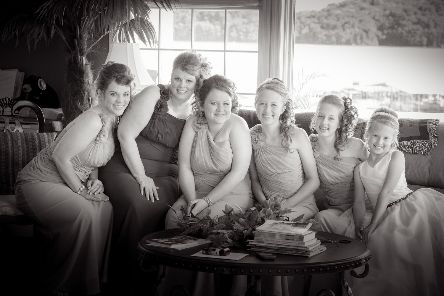 A black and white photograph shows a group gathered around a table at a social event, all dressed in elegant attire by Pigeon Forge.