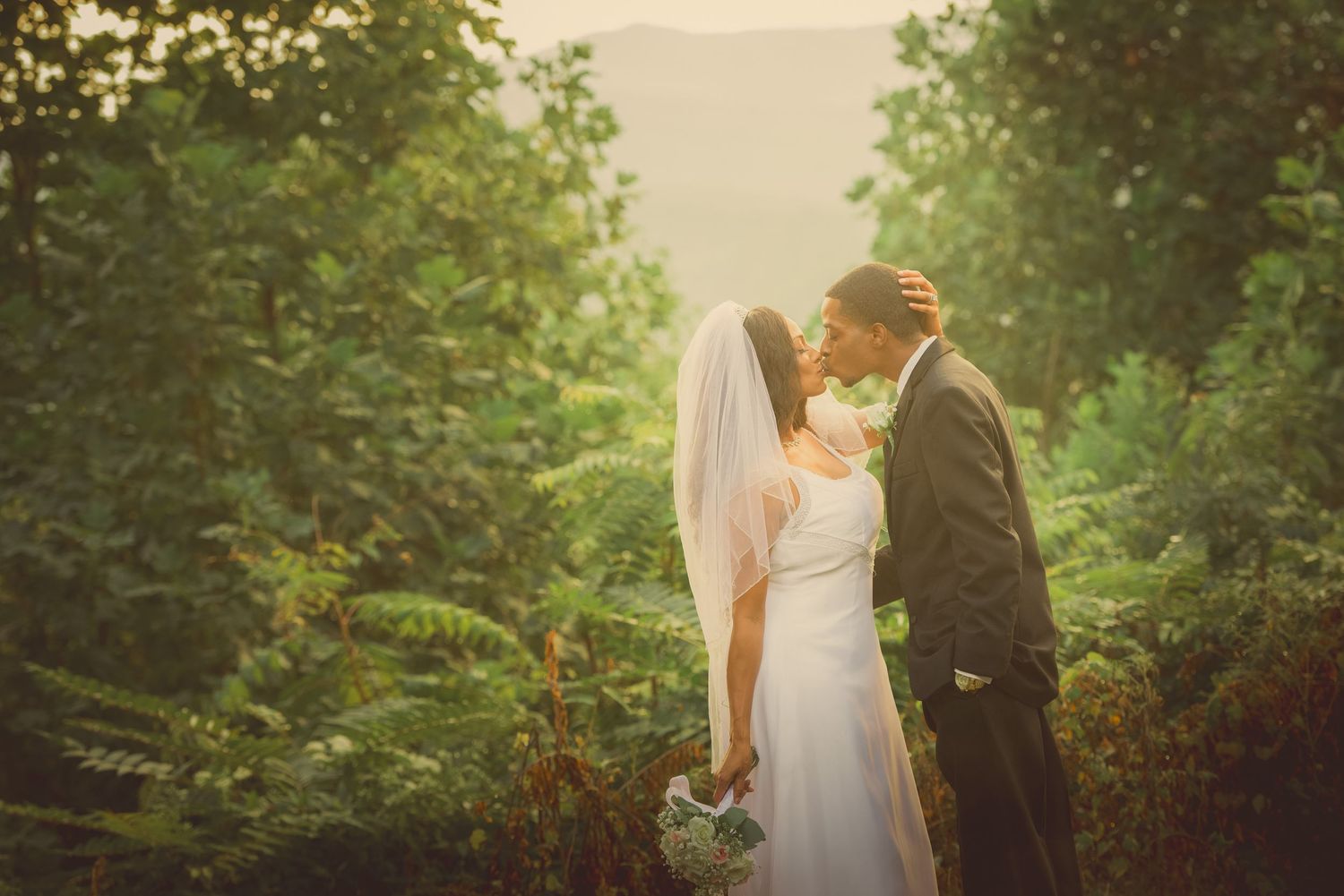 Gatlinburg Wedding Photographers portrait of a bride and groom share an intimate moment in a lush garden setting during golden hour.