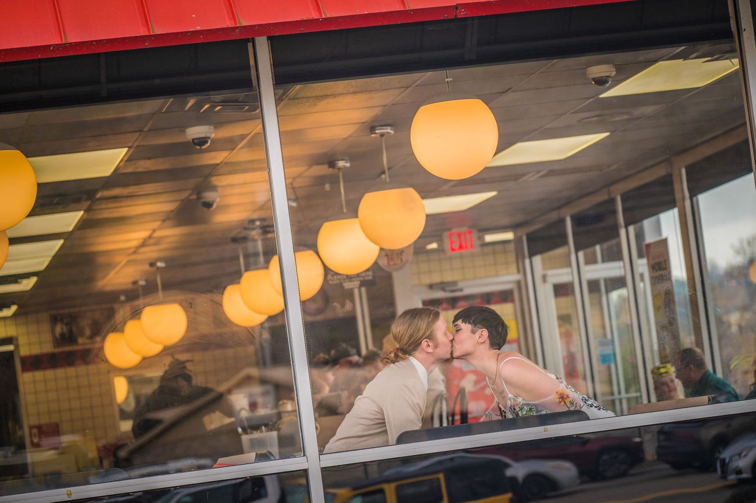 Couple sits intimately at a diner table beneath warm glowing pendant lights in the evening at Waffle House