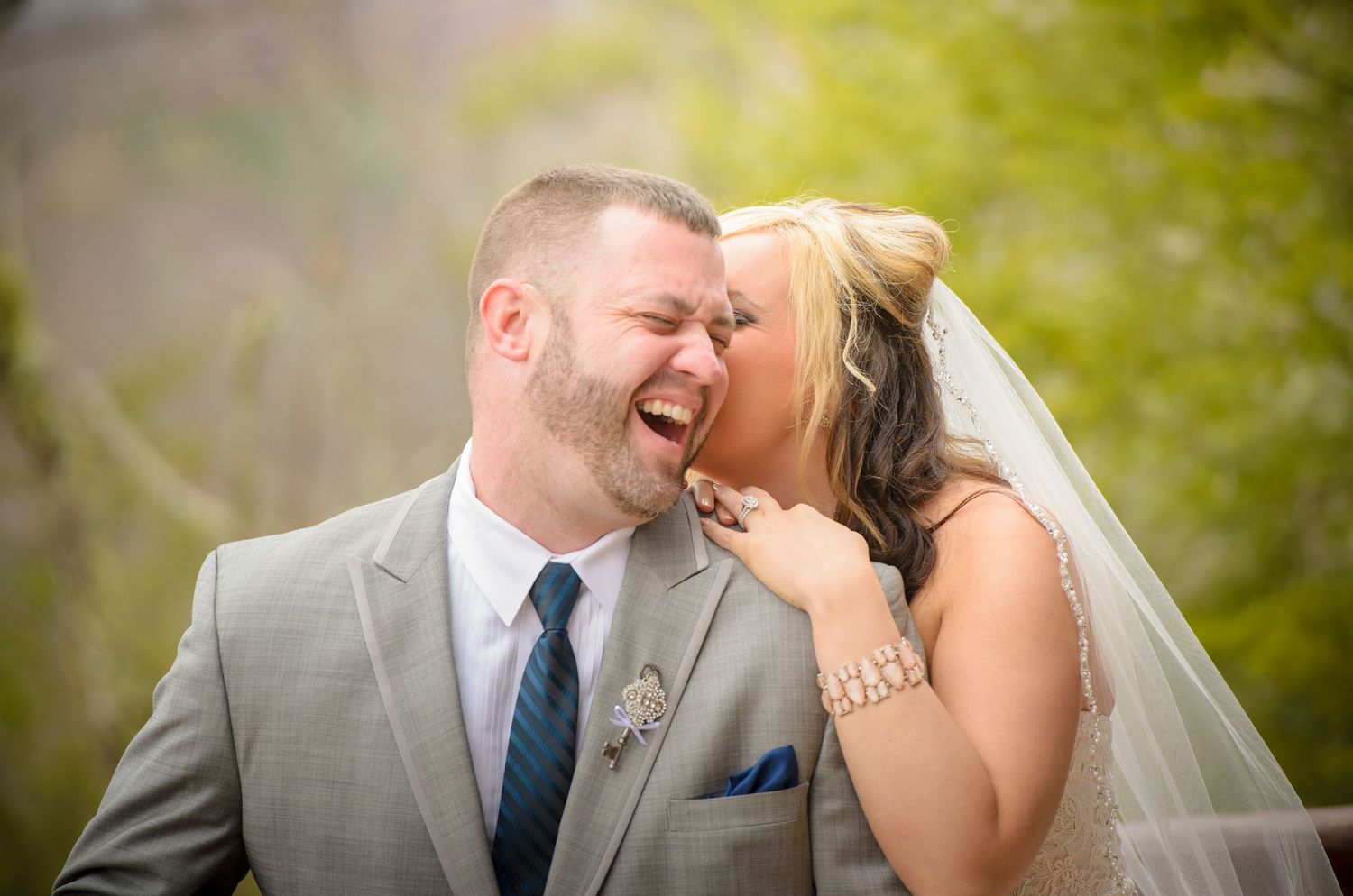 A happy couple laughing and sharing a tender moment together on their wedding day outdoors in natural lighting in Gatlinburg TN.