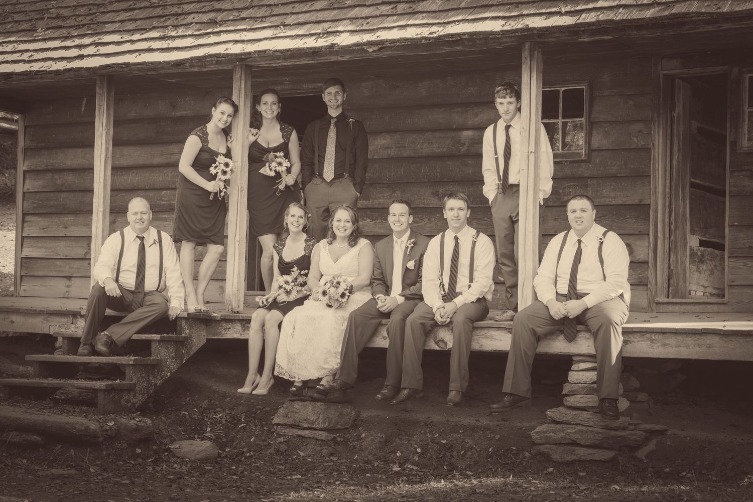 Vintage sepia photograph showing a group of people in formal attire seated and standing on a rustic wooden porch in Sevierville TN.