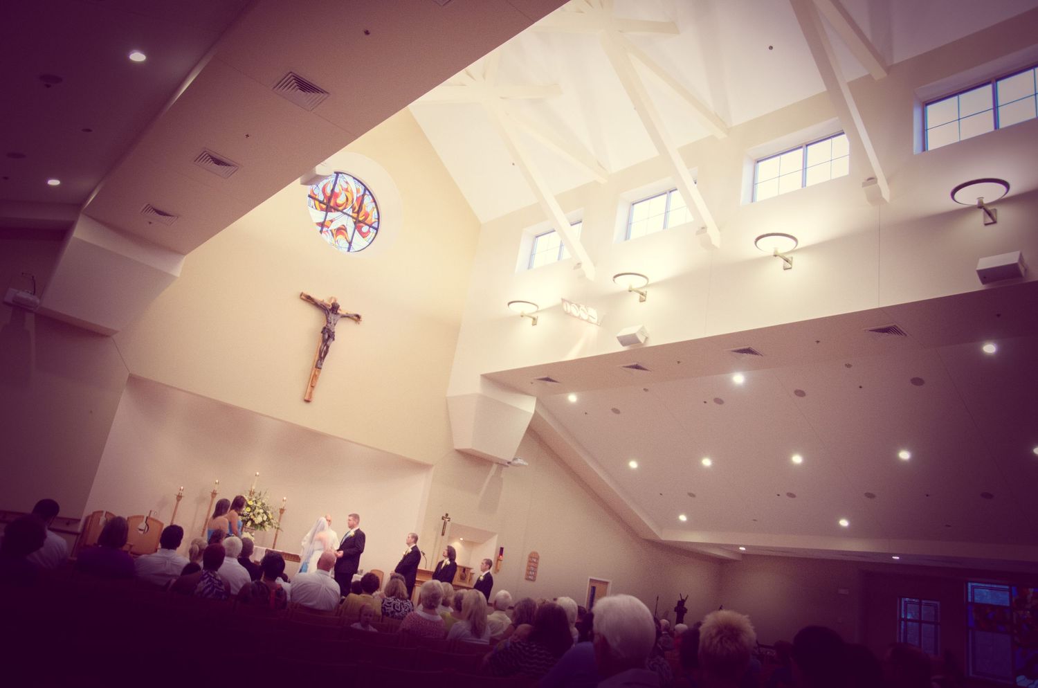 Interior view of a modern Catholic church during a service showing a crucifix, skylights and congregation in pews in Knoxville TN.
