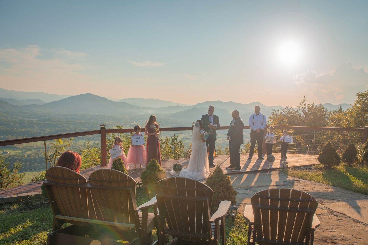 Mountain wedding ceremony taking place on a scenic overlook with wooden Adirondack chairs at sunset by gatlinburg tn wedding photographers.