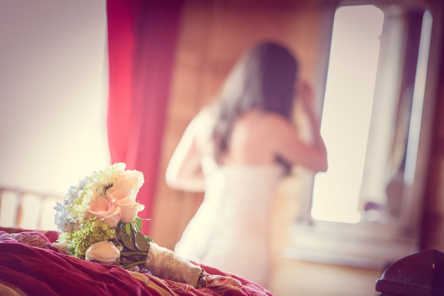 A romantic bridal bouquet of white and blush roses sits in the foreground while a blurred figure appears in the background in Sevierville.