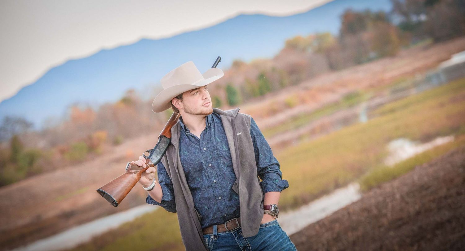 High School Senior portrait of a young man with mountains in background by the best senior portrait school pictures artist in Sevierville.