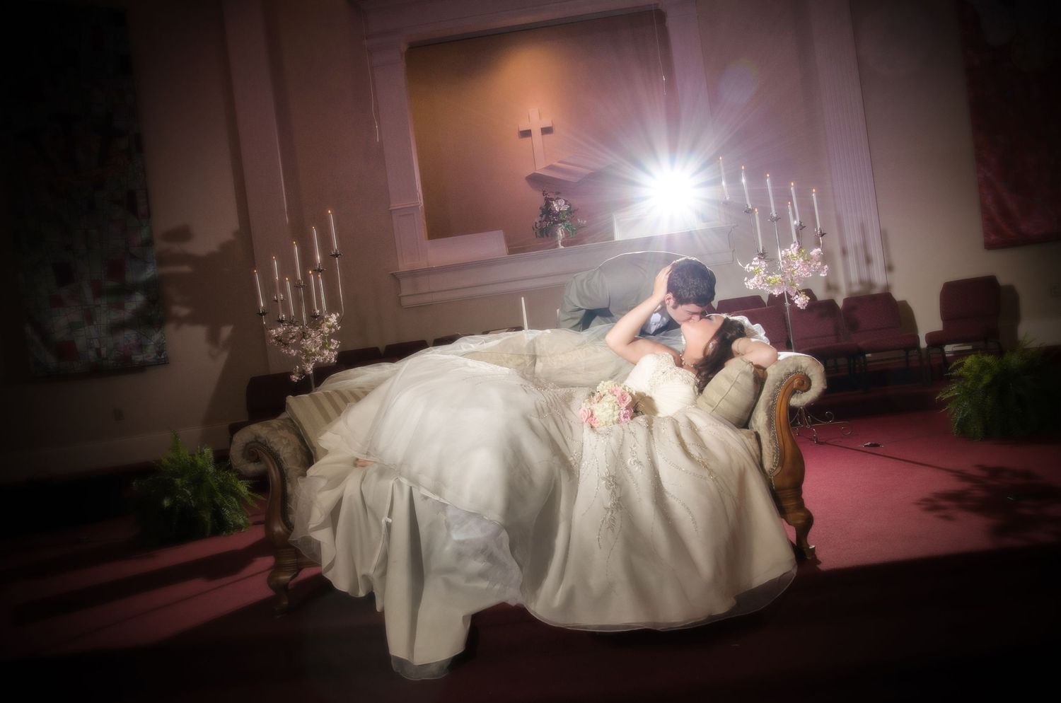 sevierville tn wedding photographers portrait of couple kissing on couch with dynamic professional lighting.