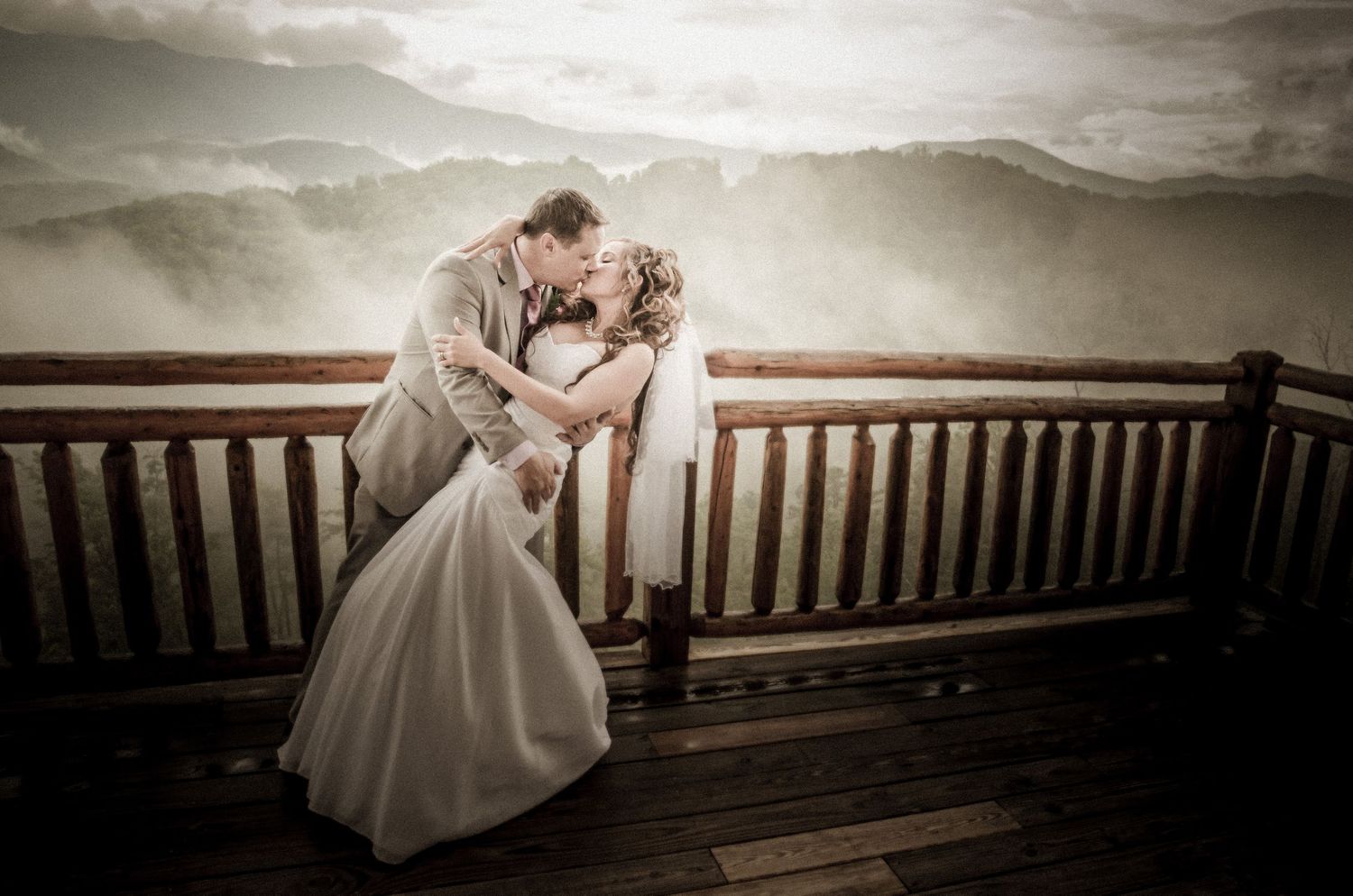 Gatlinburg Wedding Photographers portrait in romantic wedding photo taken on a wooden deck with dramatic cloudy skies in the background.