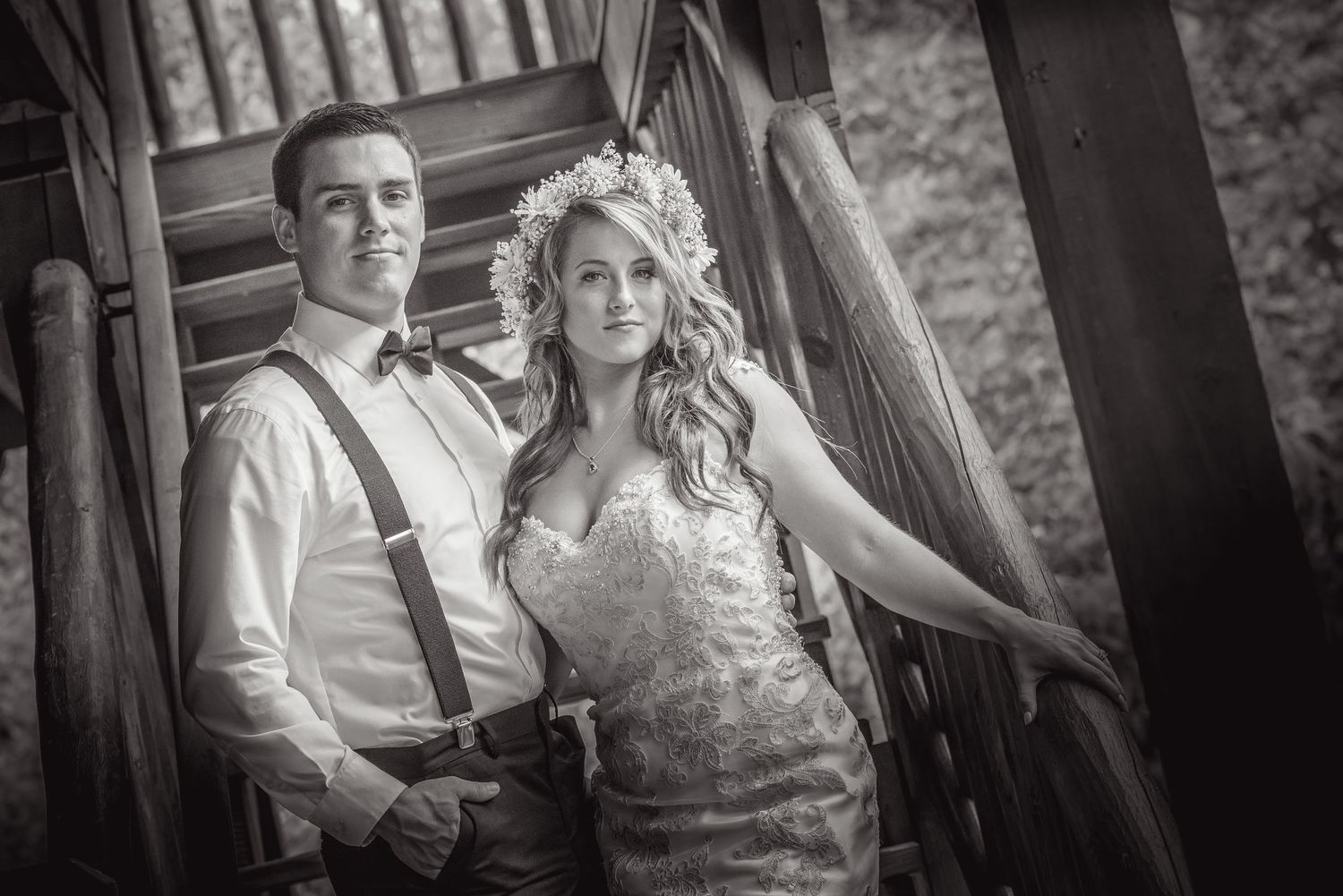 A romantic black and white wedding photograph of a couple posing together on rustic wooden stairs outdoors by Gatlinburg Weddings TN.