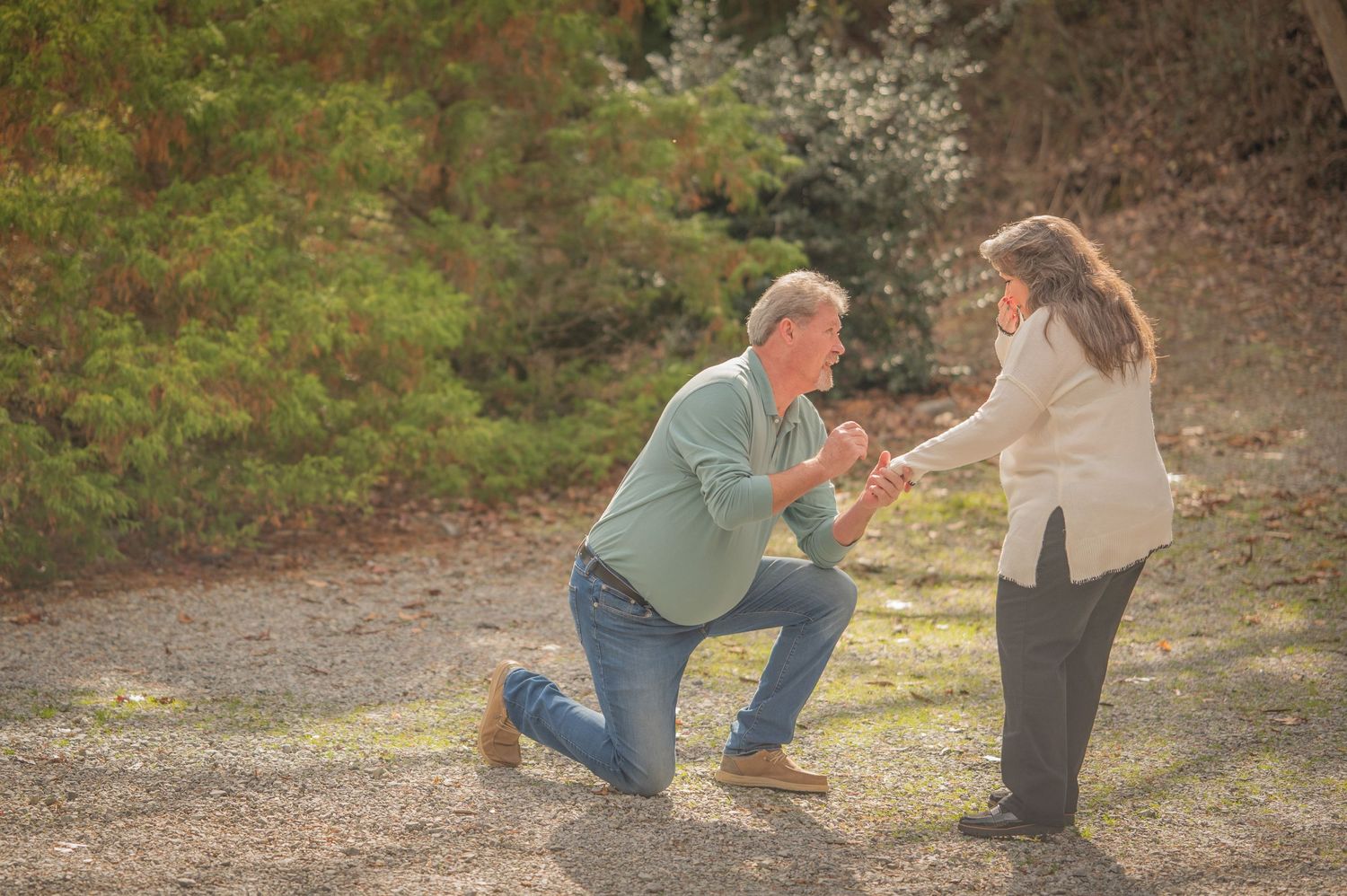 A surprise proposal on a dirt path in a natural setting during golden hour by Cosby Photographers.