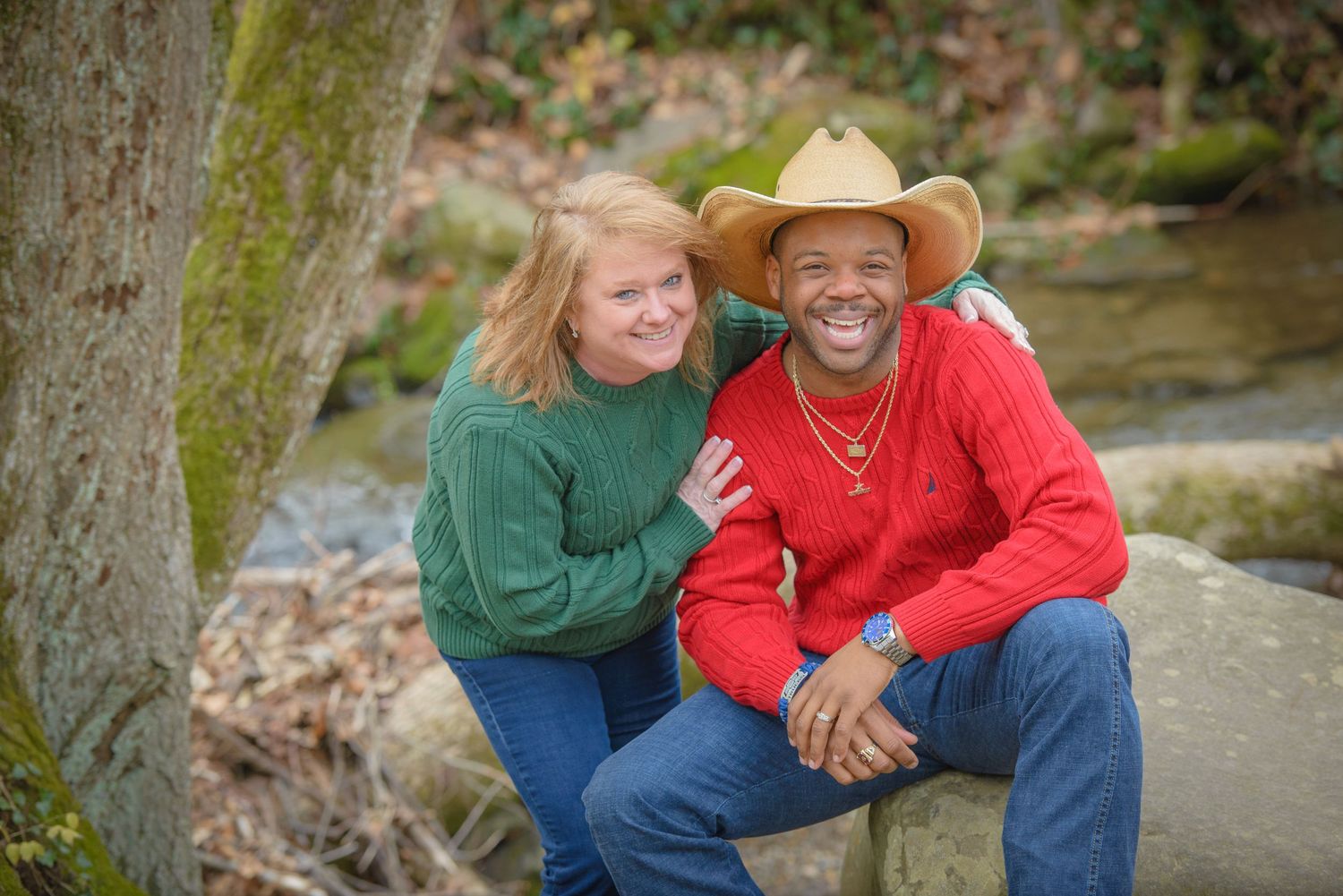 Two friends enjoying a casual outdoor moment together by a creek while wearing casual sweaters by Sevierville TN Photographers.