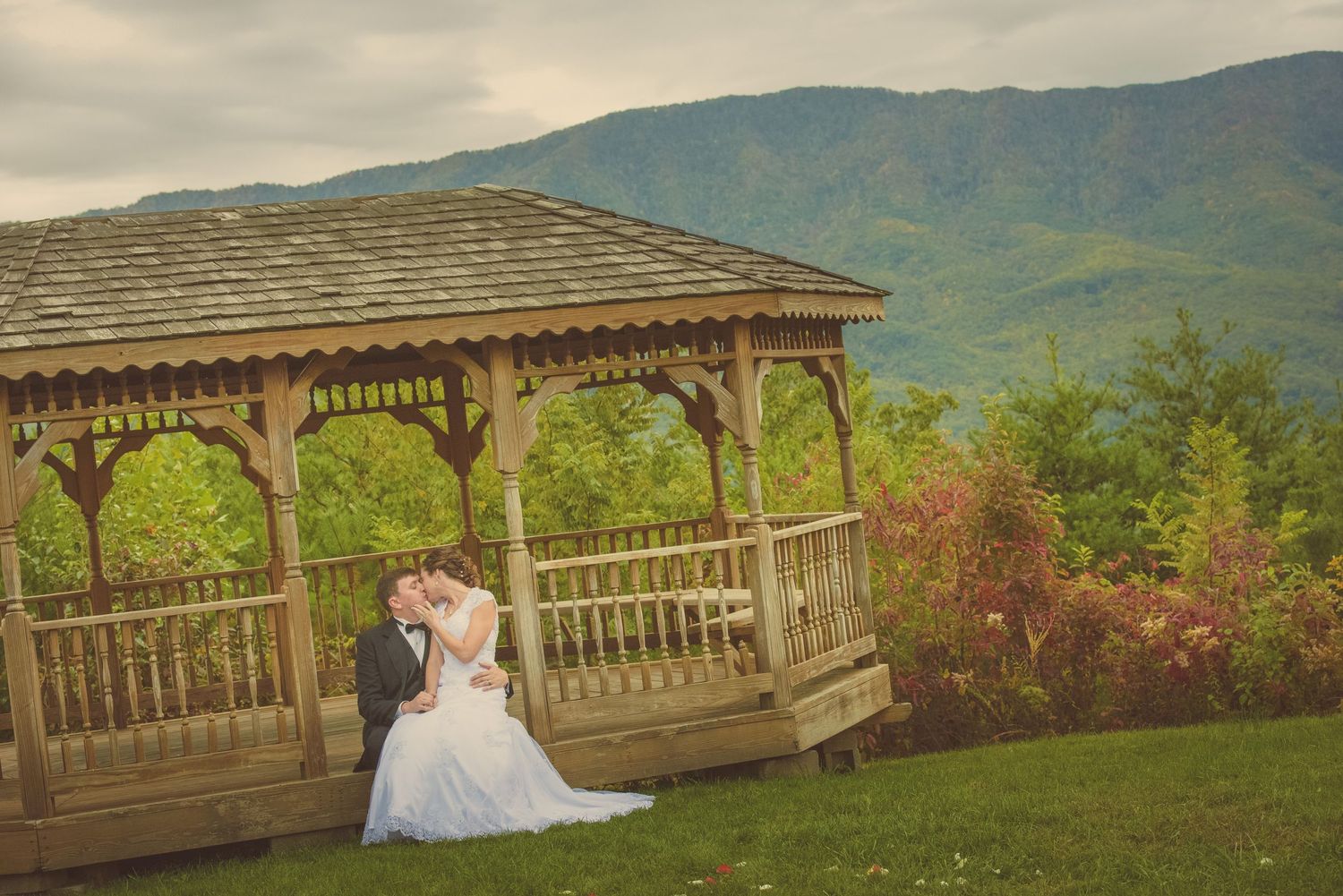 A wooden gazebo set against misty mountain scenery with vibrant greenery and romantic atmosphere by Gatlinburg TN Wedding Photographers.