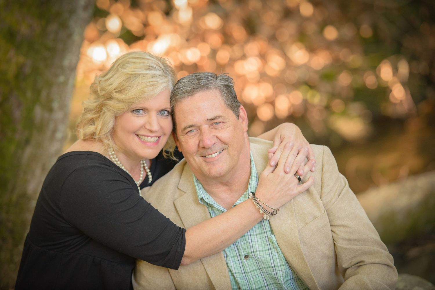An affectionate outdoor portrait of a couple embracing in warm autumn lighting with soft bokeh in background by Townsend TN Photographers