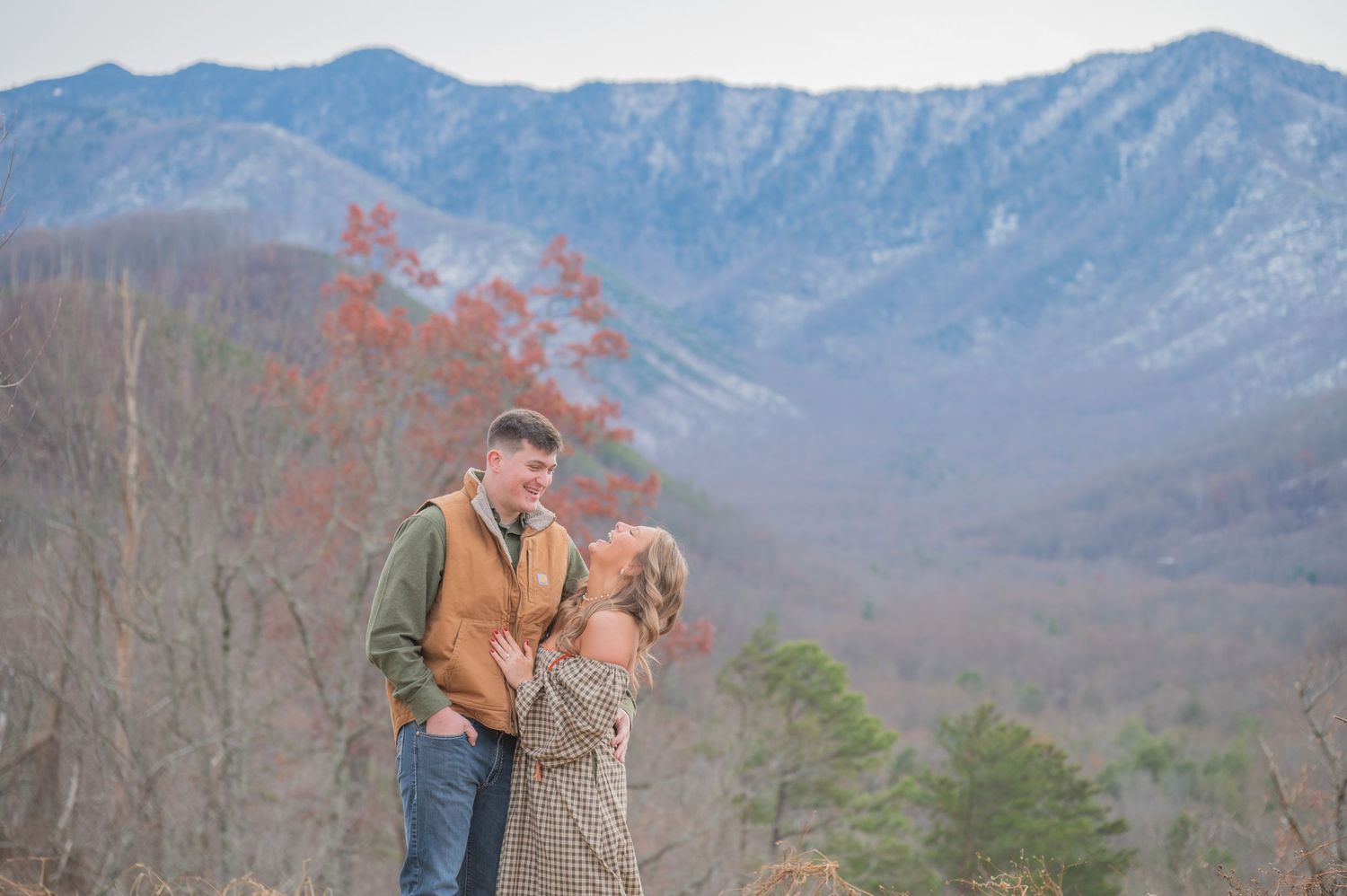 A couple embraces while enjoying scenic mountain views in autumn along the Blue Ridge Mountains by Sevierville TN Photographers.