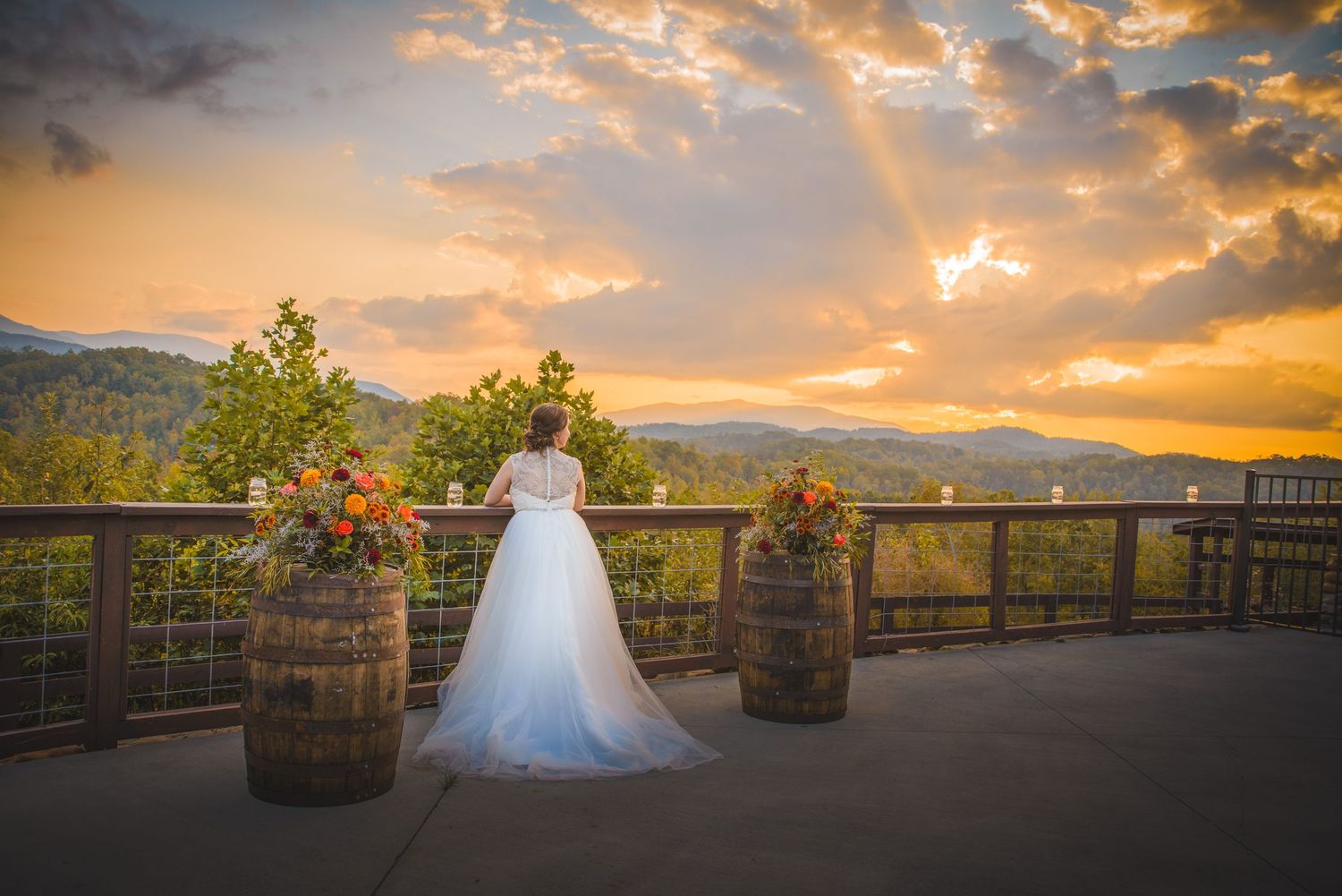 Pigeon Forge Weddings portrait at a scenic sunset wedding venue on a mountain terrace with wooden barrels and a white wedding dress.