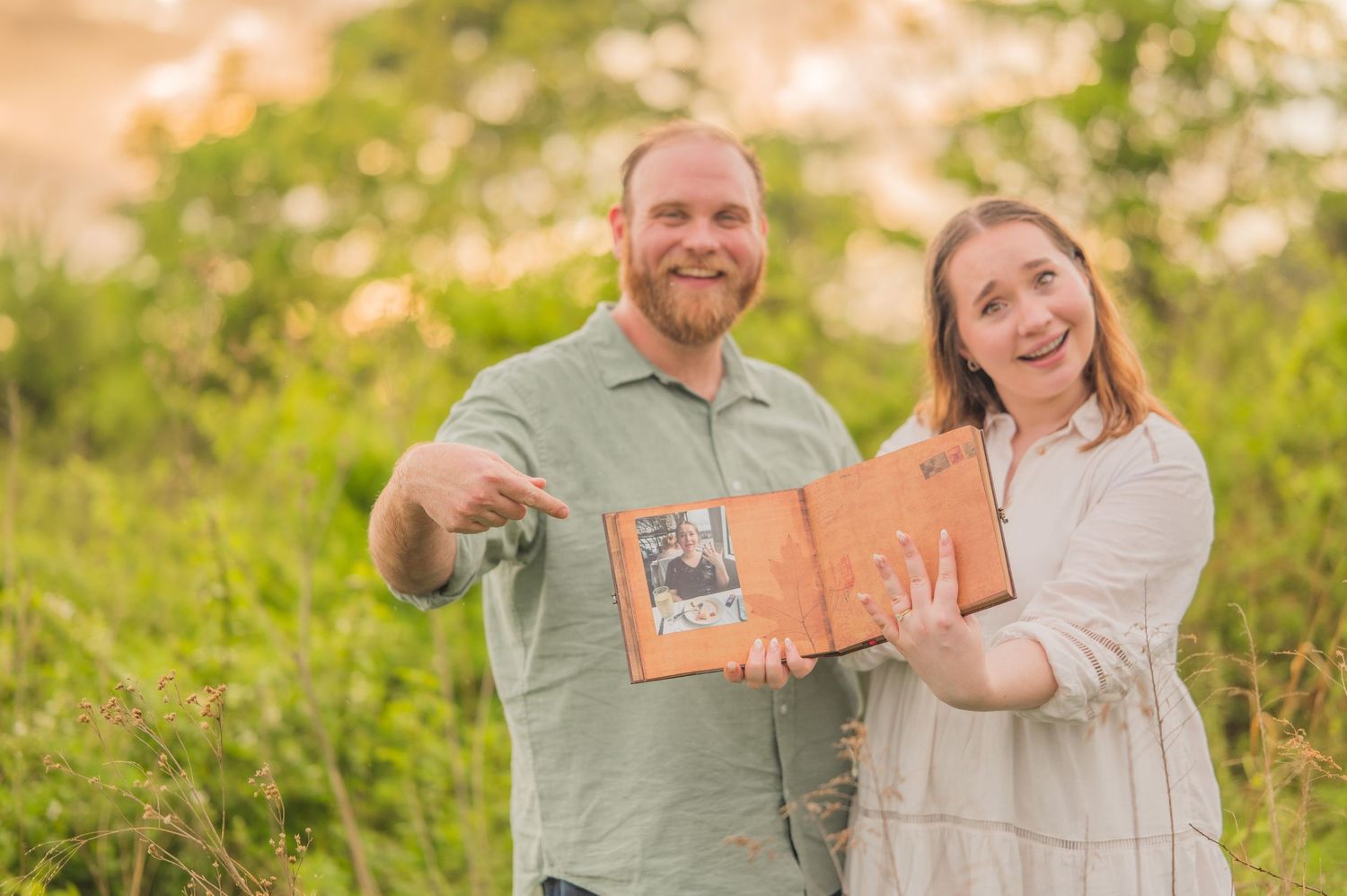 An engagement portrait of a couple pointing at a memory book by Gatlinburg Photographers TN Smoky Mountain Portraits by Benjamin