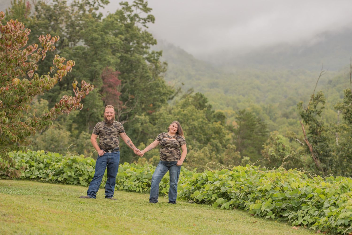 gatlinburg engagement photographers portrait of a couple against a mountain backdrop with green foliage in Tennessee.