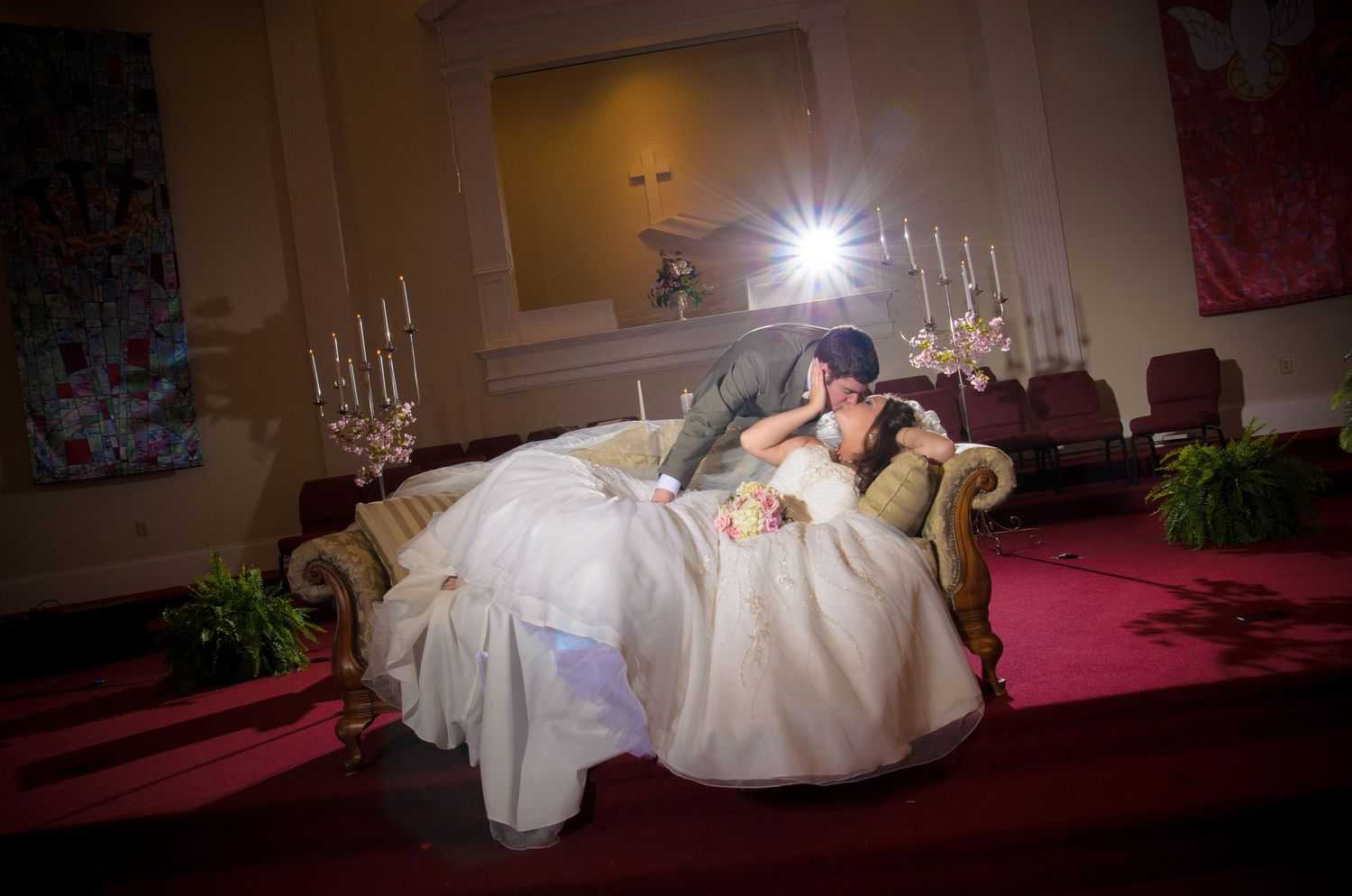 A romantic wedding scene inside a church with a bride and groom sharing an intimate moment surrounded by candlelight by Gatlinburg Weddings.