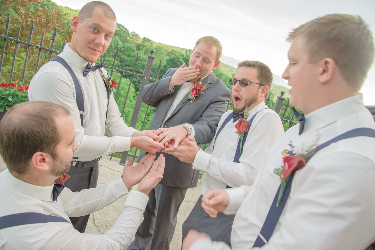 Groomsmen in navy suspenders and bowties share drinks and laughs during an outdoor wedding celebration by Pigeon Forge Wedding Photographers