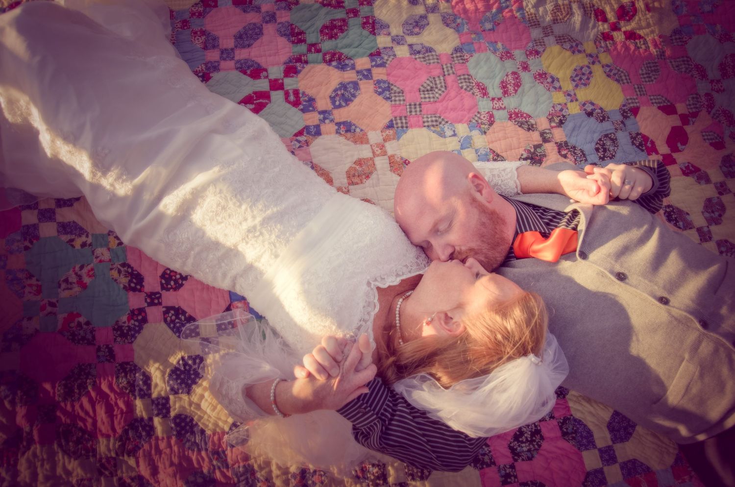Two people lying down together on a colorful patterned blanket in warm sunlight in Sevierville TN.