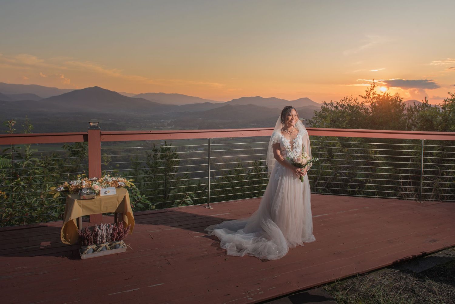 Elegant wedding scene on mountain deck at sunset with rustic table display and stunning mountain vista backdrop by gatlinburg photographers.