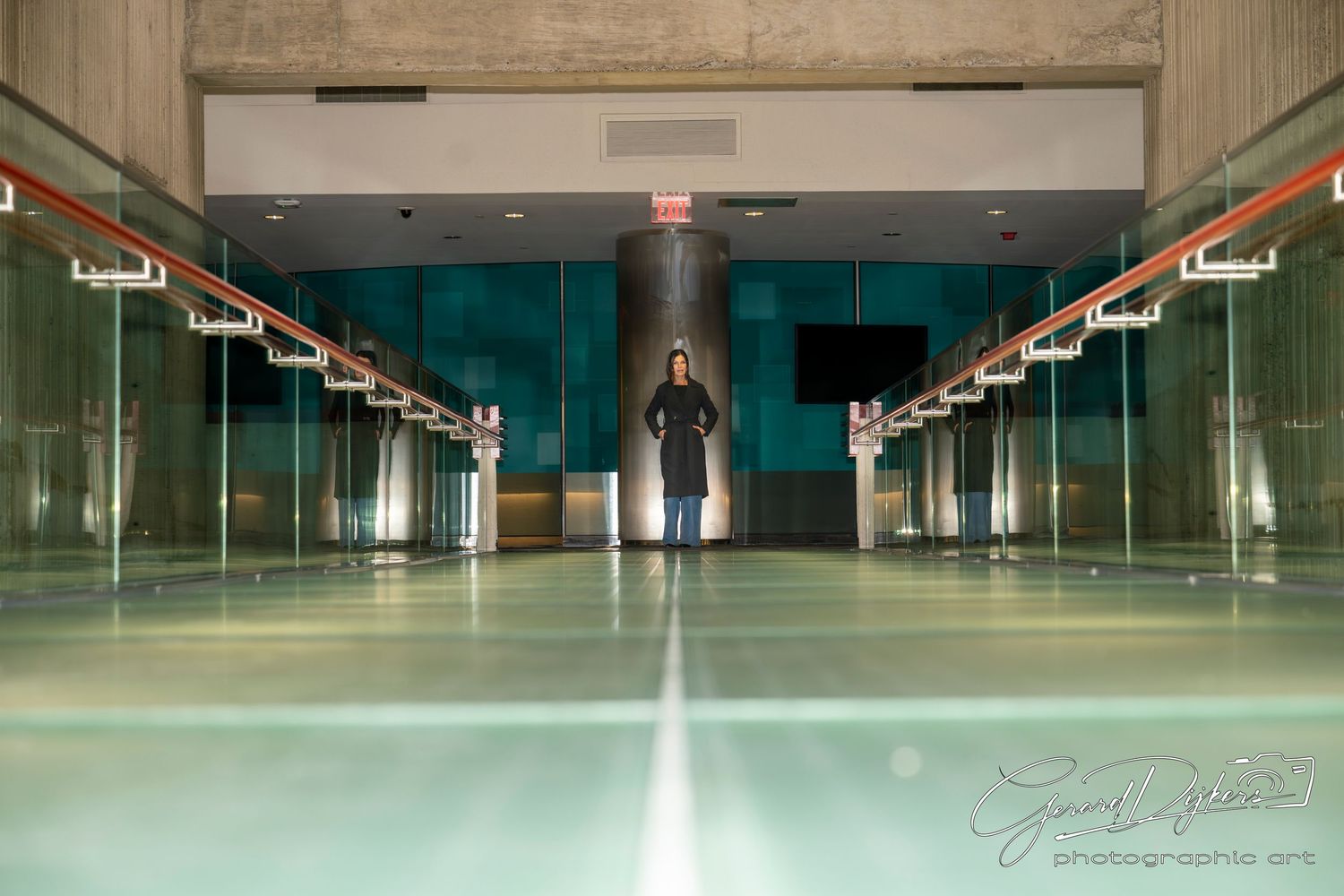 Empty indoor parking garage with polished green epoxy floor and fluorescent lighting stretches into the distance.