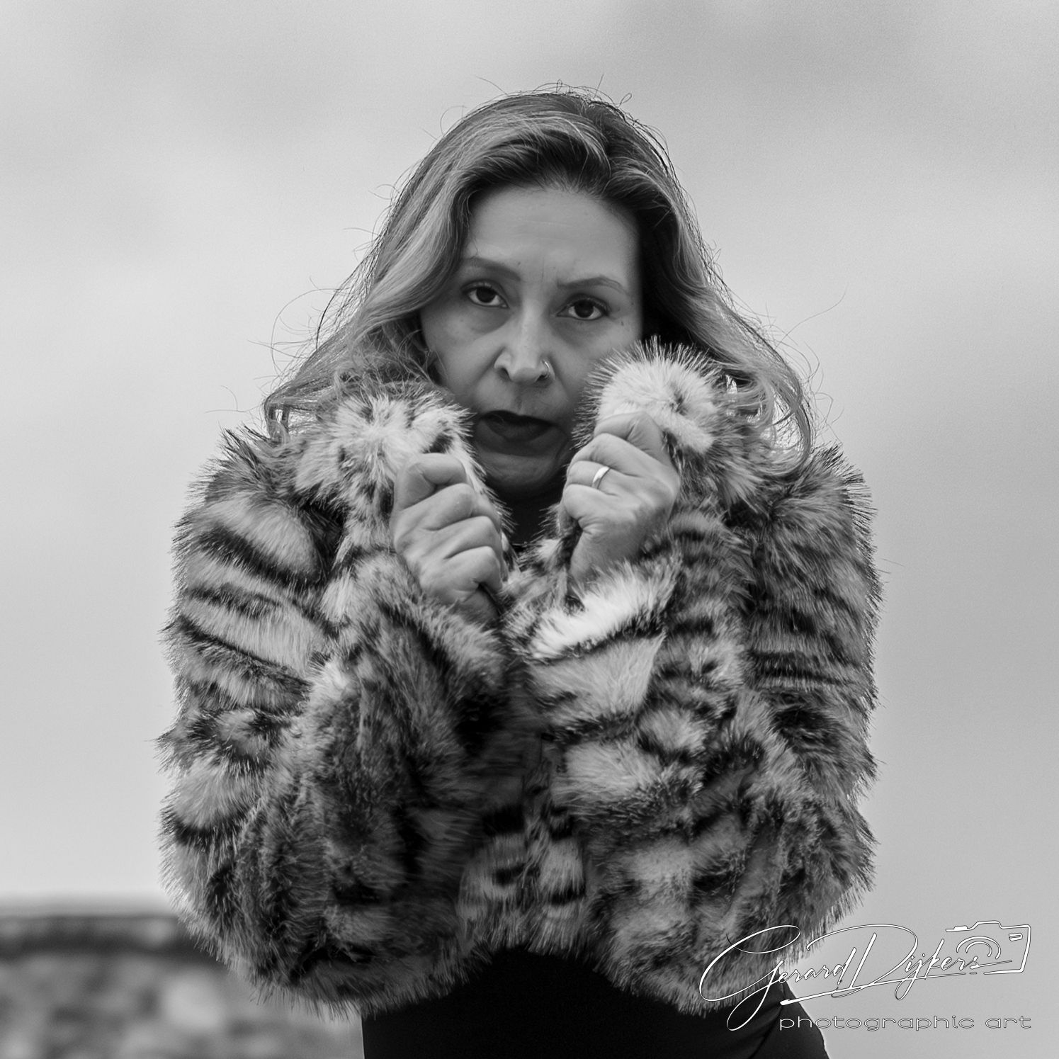 Black and white portrait series showing dramatic expressions and poses with a fur collar against a light background.