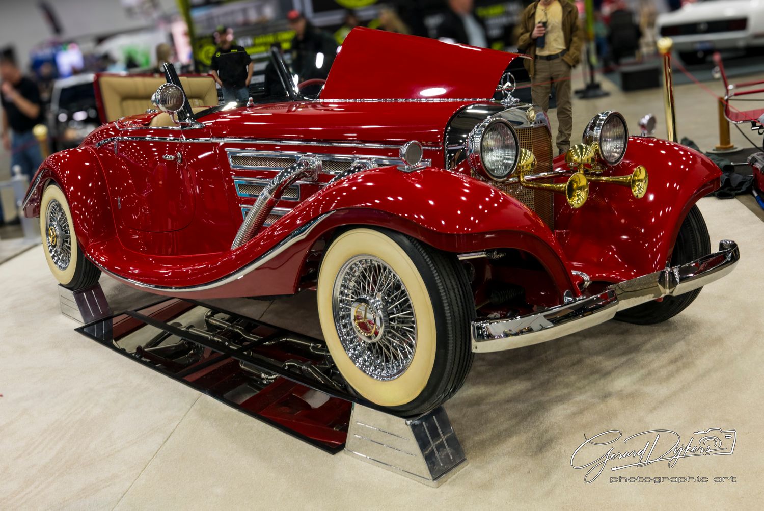 Stunning red vintage Mercedes-Benz 500K convertible with cream-colored wheels on display.