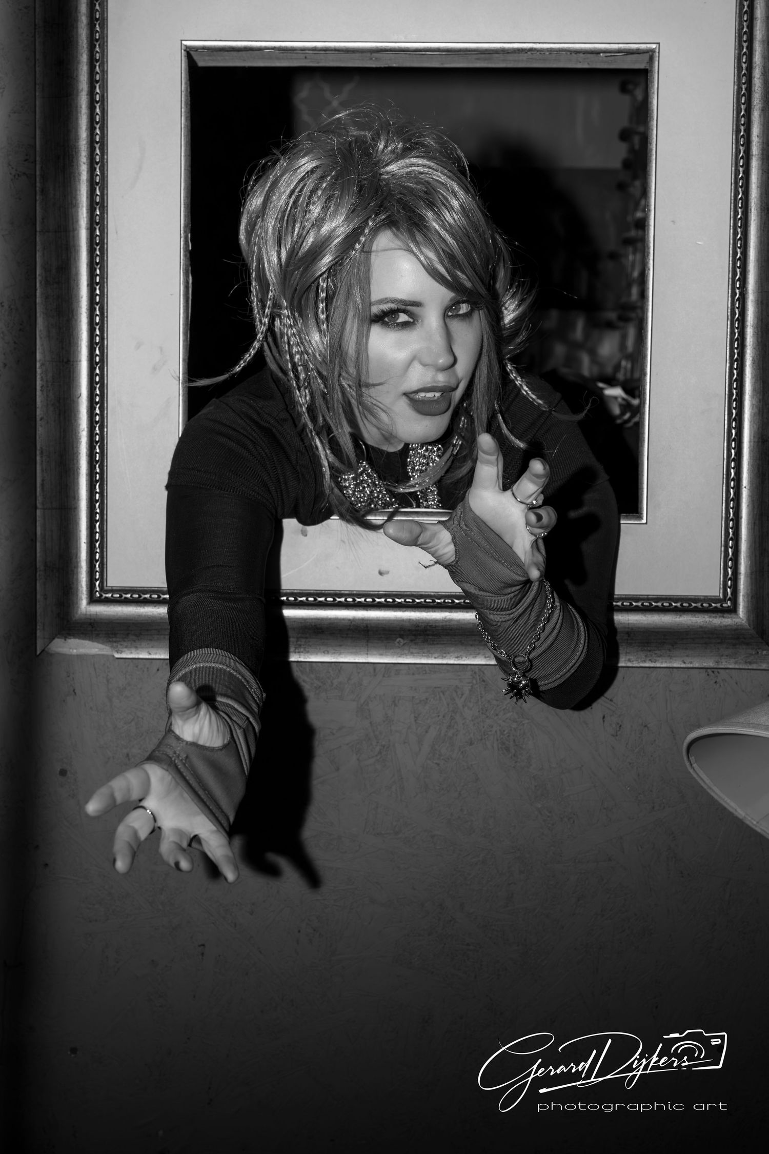 A black and white photo series showing dramatic portraits with moody lighting and framed artwork in the background.
