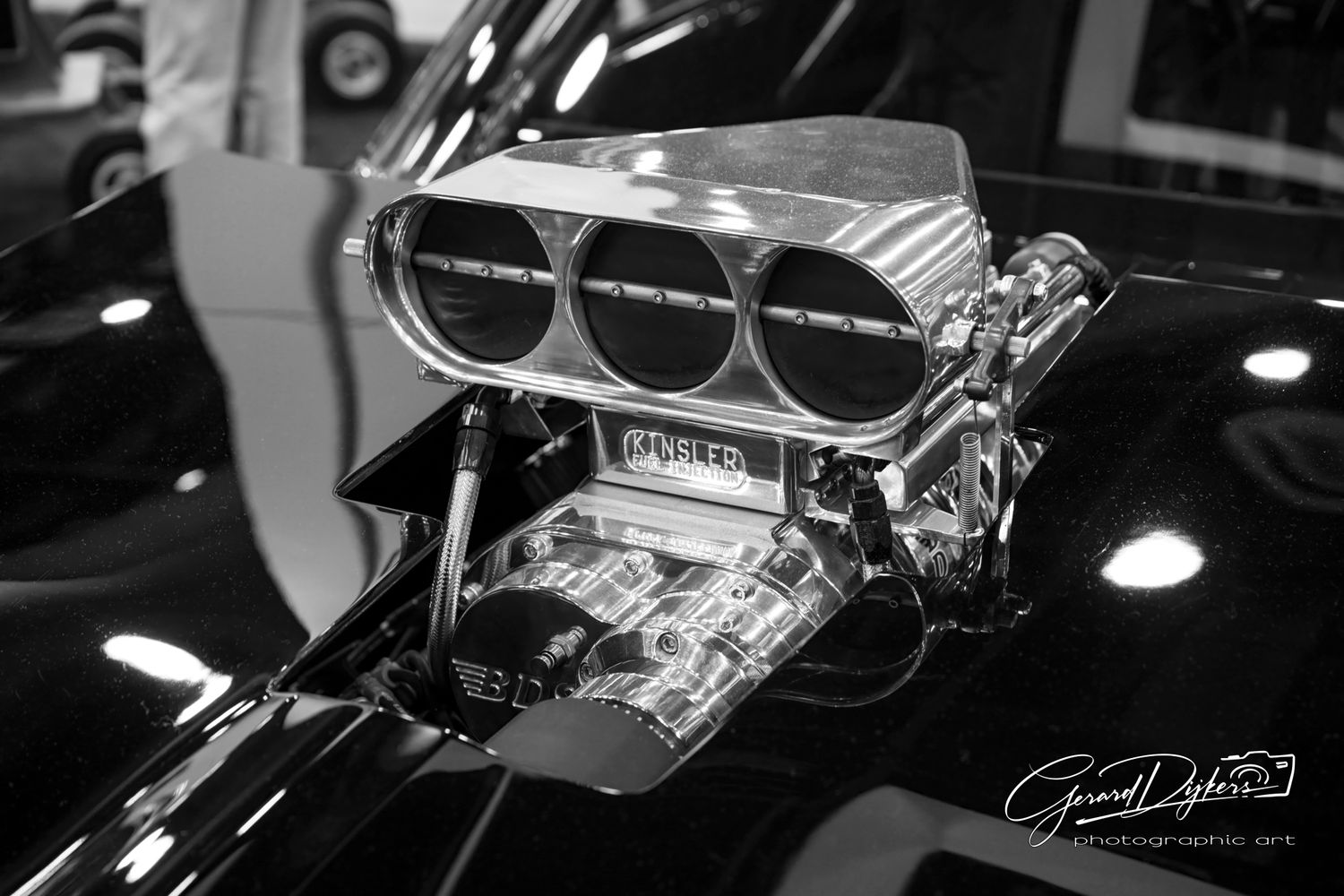Close-up view of a classic car's chrome engine components and mechanical details in black and white.