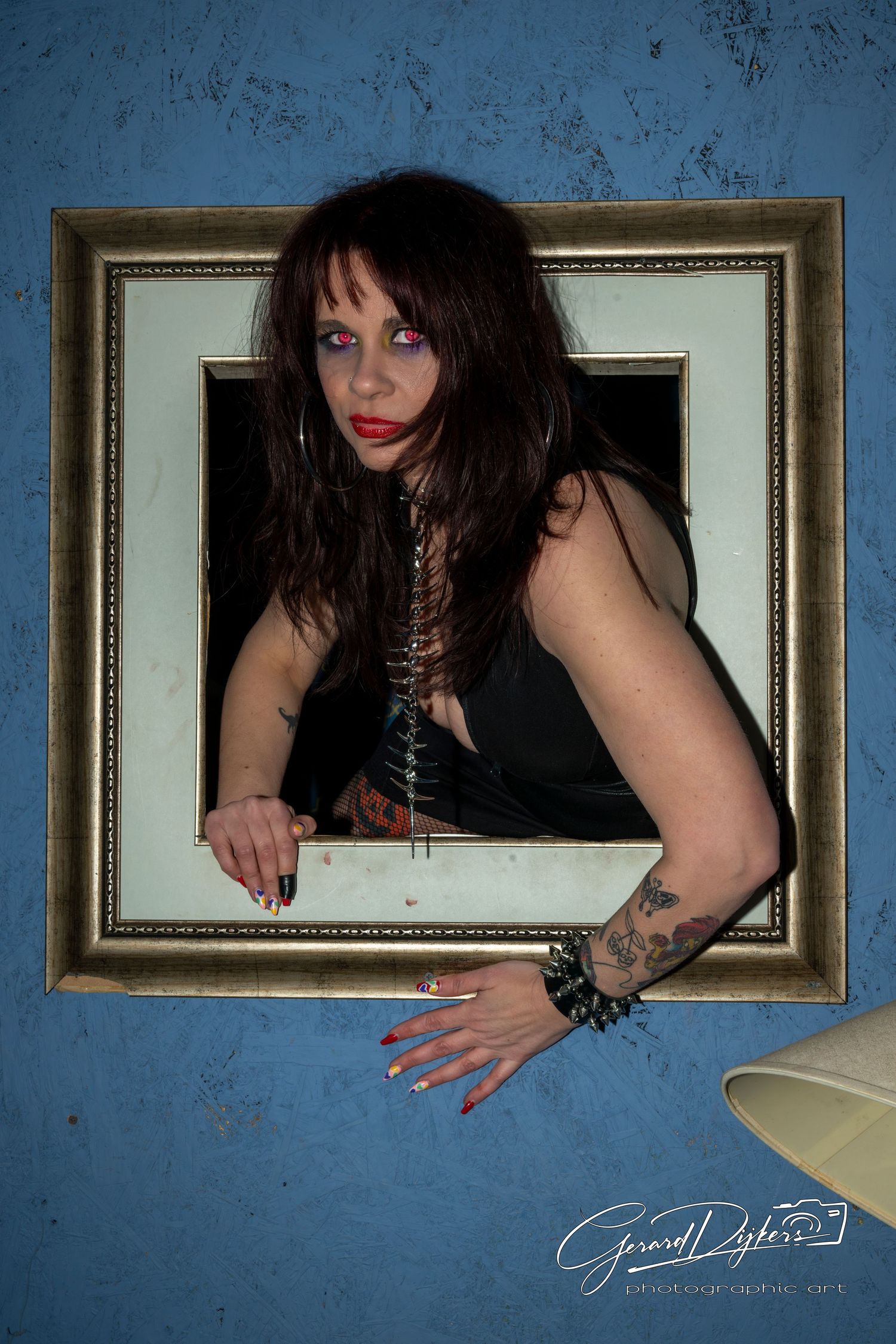 A creative photo series showing hands reaching through ornate gold picture frames against a textured blue wall.