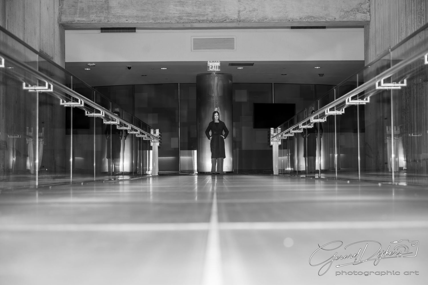 Large empty industrial warehouse interior with polished concrete floors and fluorescent lighting stretching into the distance.