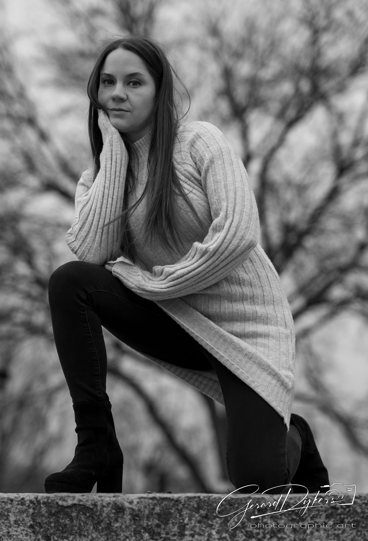 Artistic black and white portrait series showing a woman in a knit sweater posing against a blurred natural backdrop.
