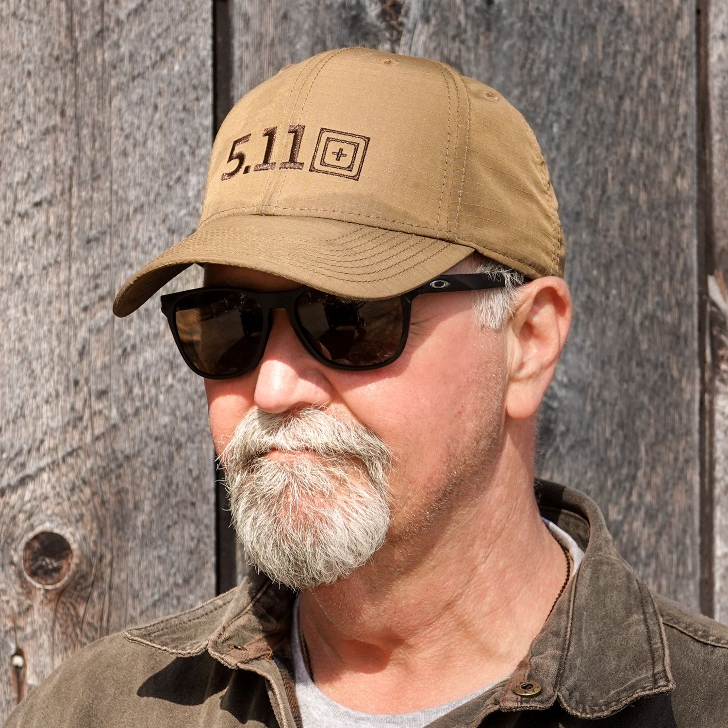 Side profile views of someone wearing a tan baseball cap and sunglasses against a rustic wooden wall background.