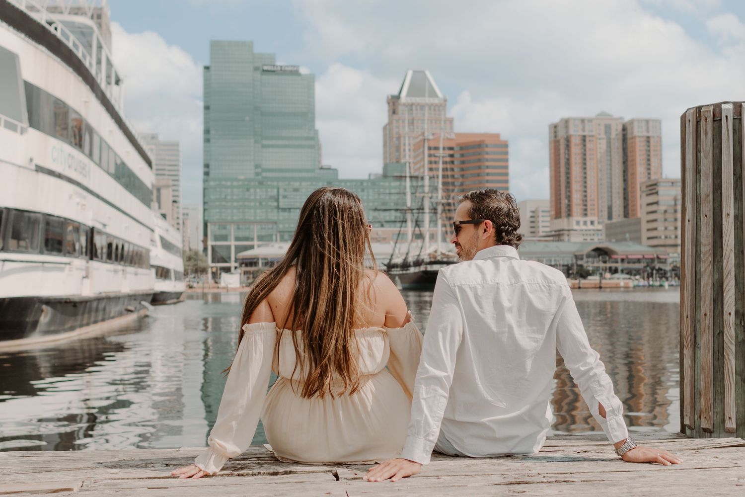 Young couple sitting and relaxing on modern urban rooftop terrace with city skyline views.