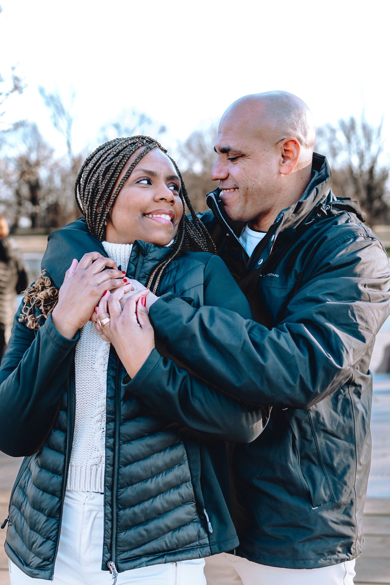 Couple sharing intimate moment outdoors wearing winter jackets.
