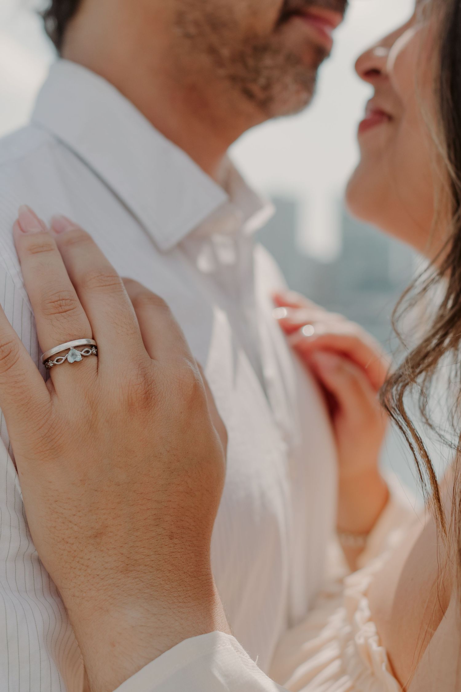 Close-up shot of an engagement ring on a hand with soft natural lighting.