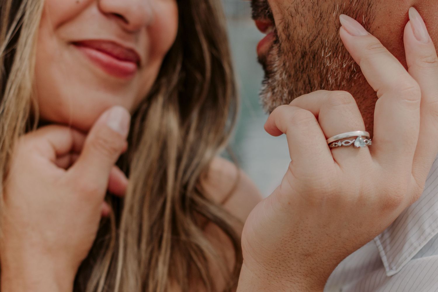 Close-up shot of hands tenderly caressing someone's face in warm lighting showing intimacy and affection.
