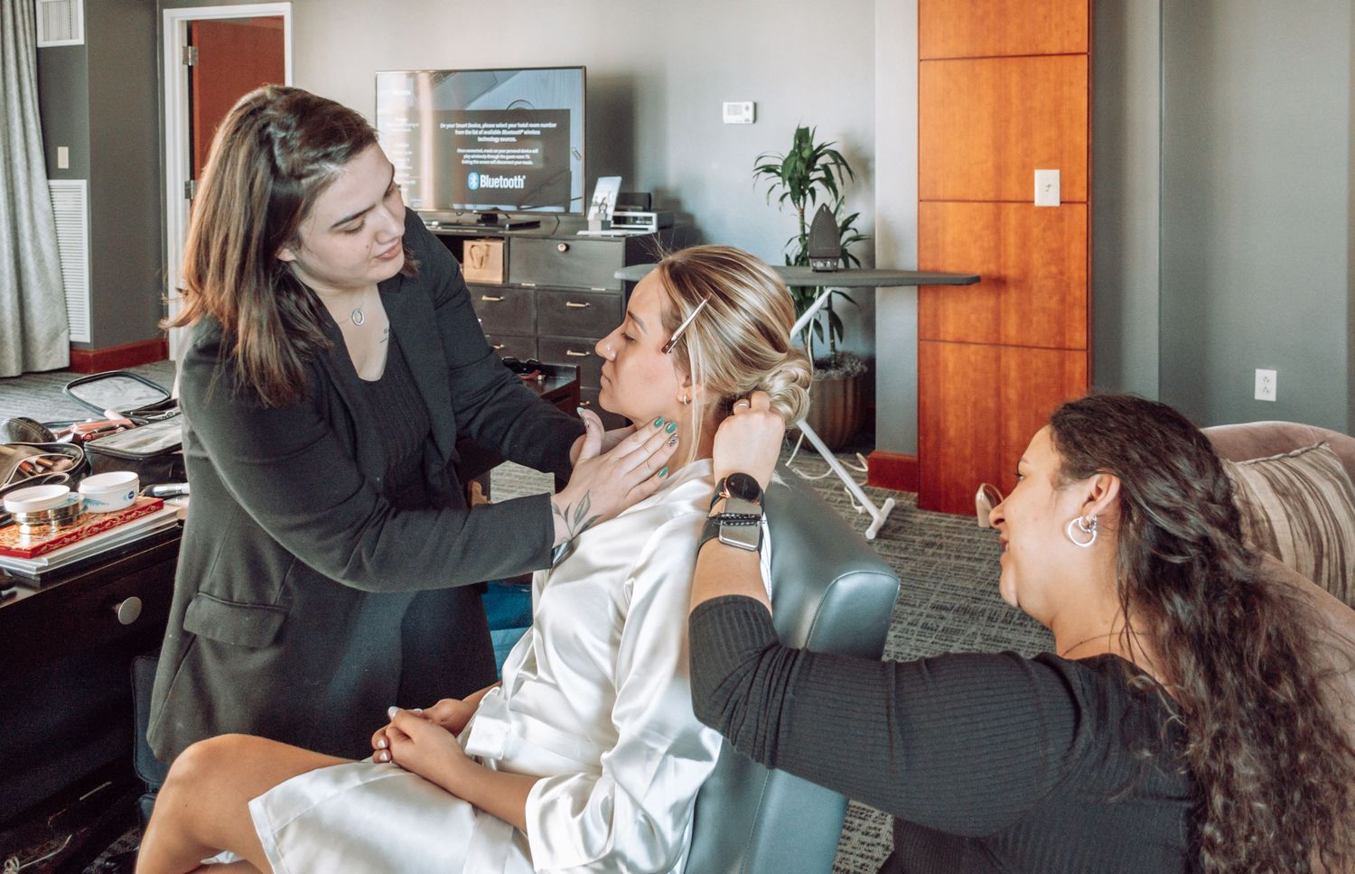 Makeup artists prepare for an event in an office setting with beauty tools and supplies.