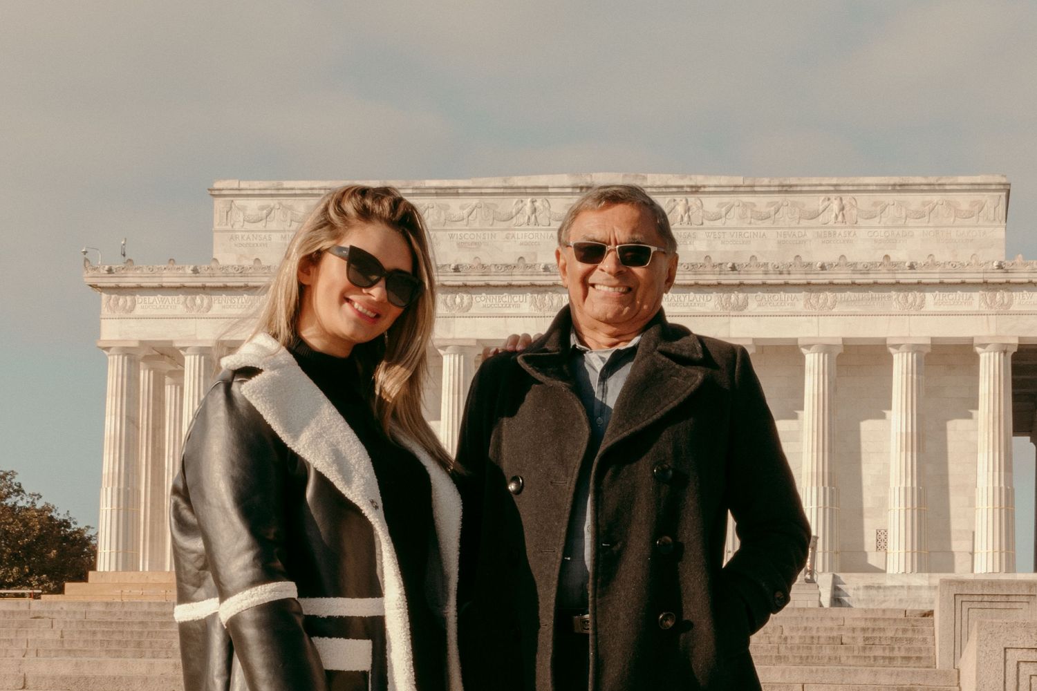 Two people pose together in front of the Lincoln Memorial in Washington DC.