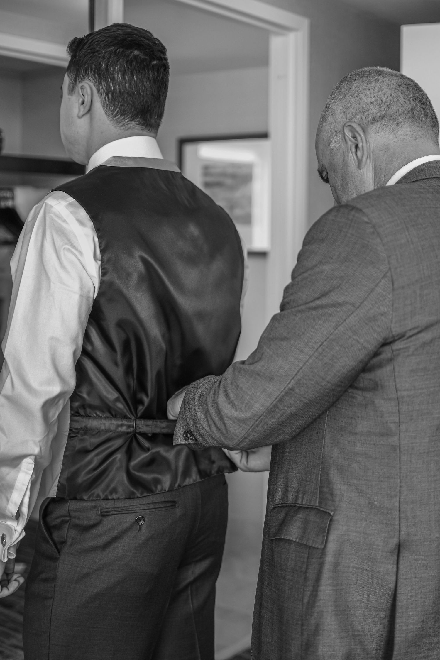 Black and white photo of two men in formal attire standing and facing away from the camera.