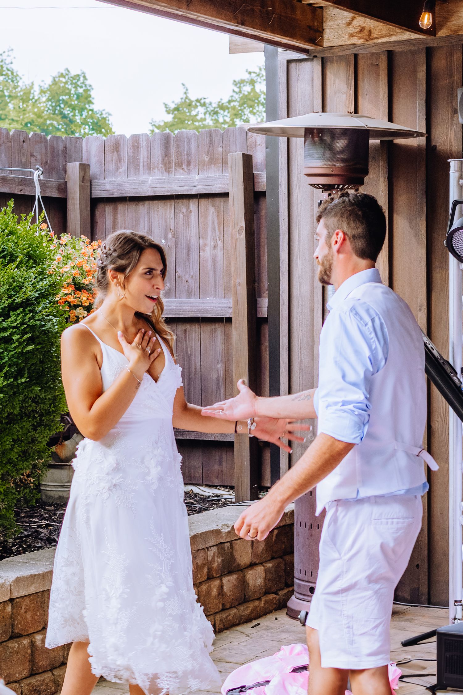A couple in white wedding attire shares a playful moment in a series of candid photos against a wooden fence background.