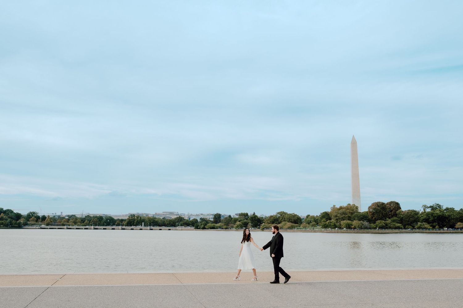 A panoramic view of the Washington Monument and Tidal Basin with cherry blossoms blooming in spring.
