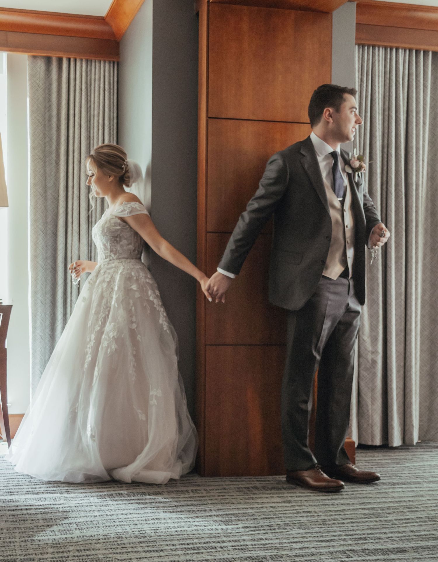 A sequence of four candid wedding moments showing a bride in a white gown and groom in a suit interacting in a hotel hallway.