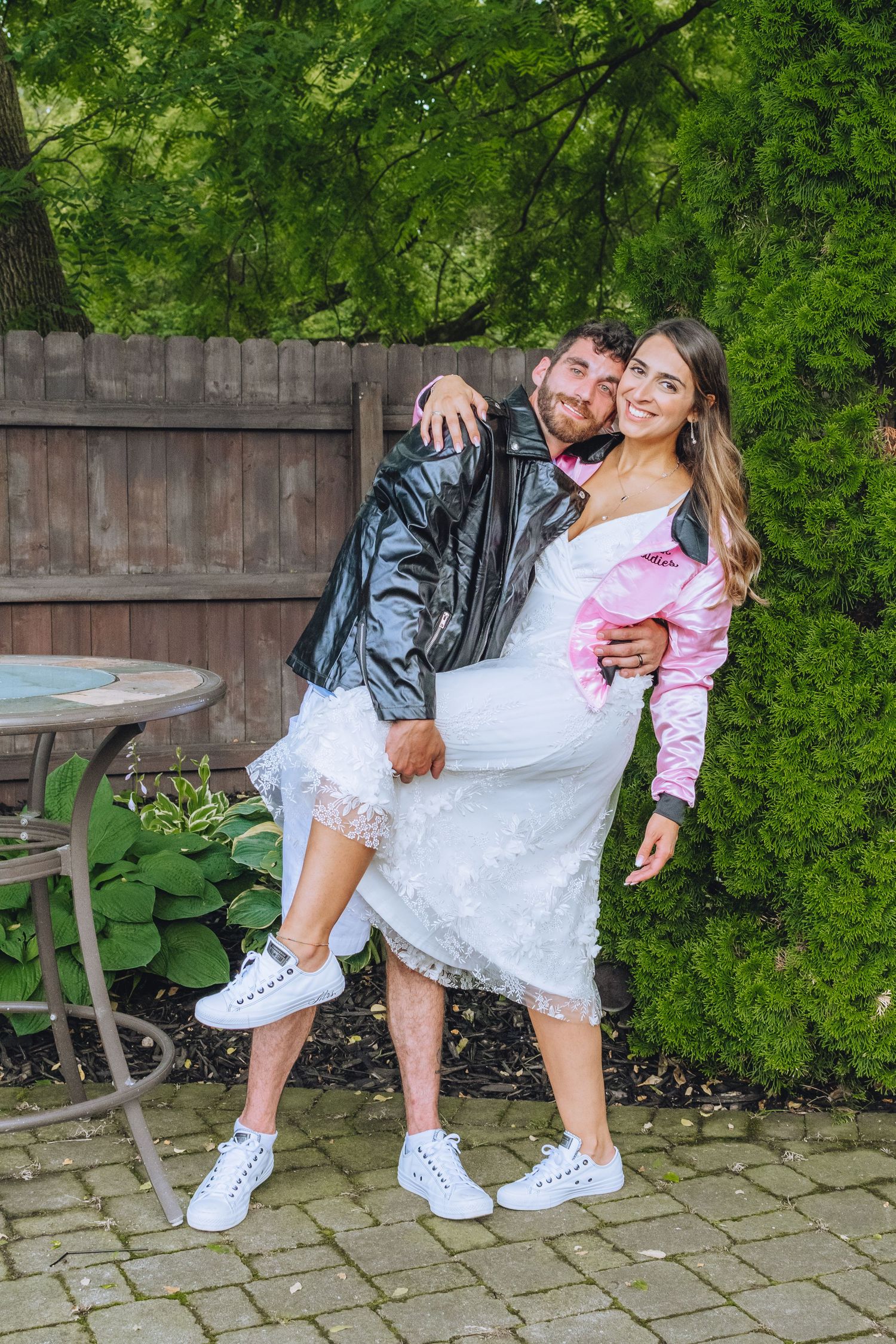 Close-up shots of white sneakers and lace dress against green garden backdrop with stone patio pavers.