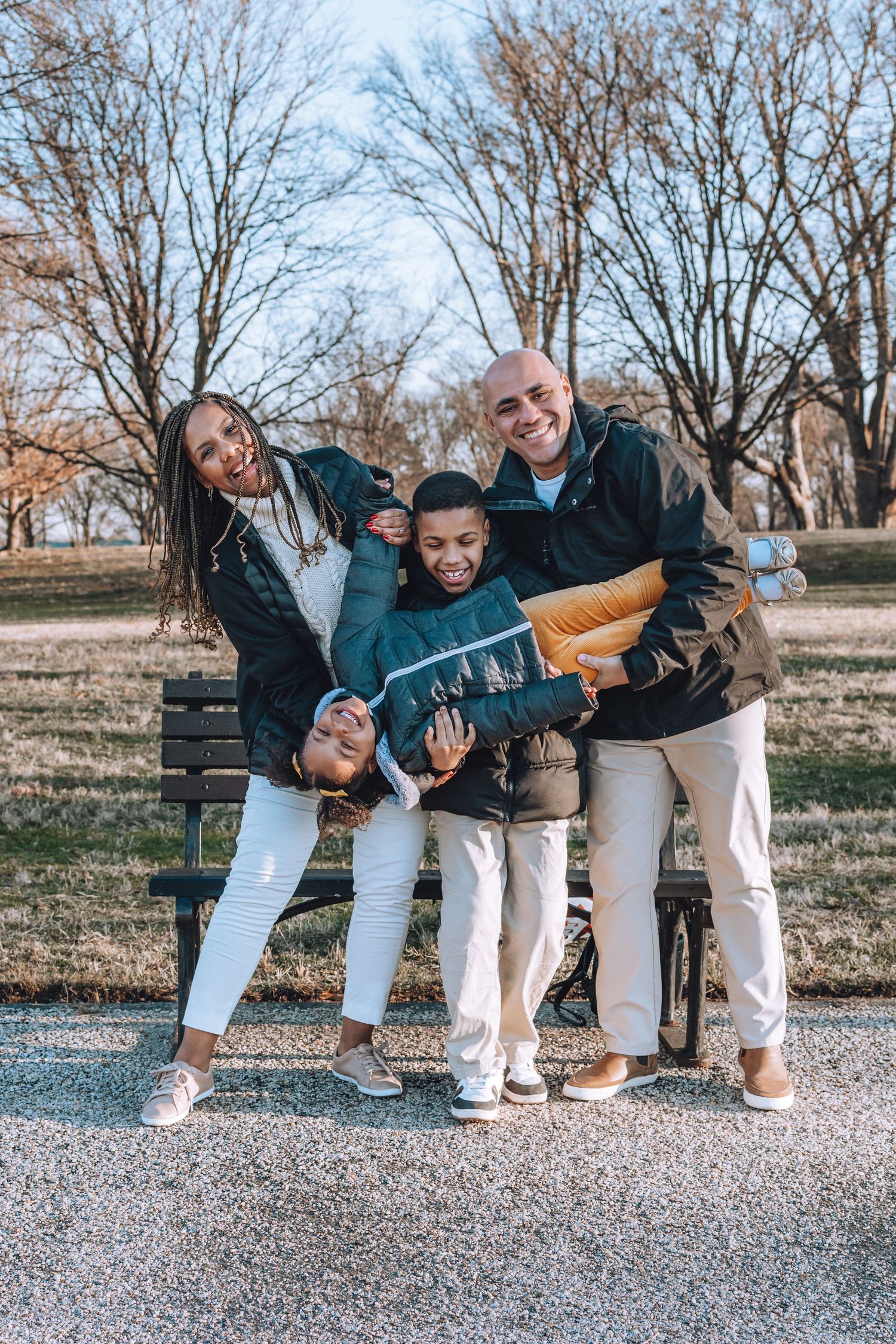 A joyful group poses playfully by a park bench on an autumn afternoon.