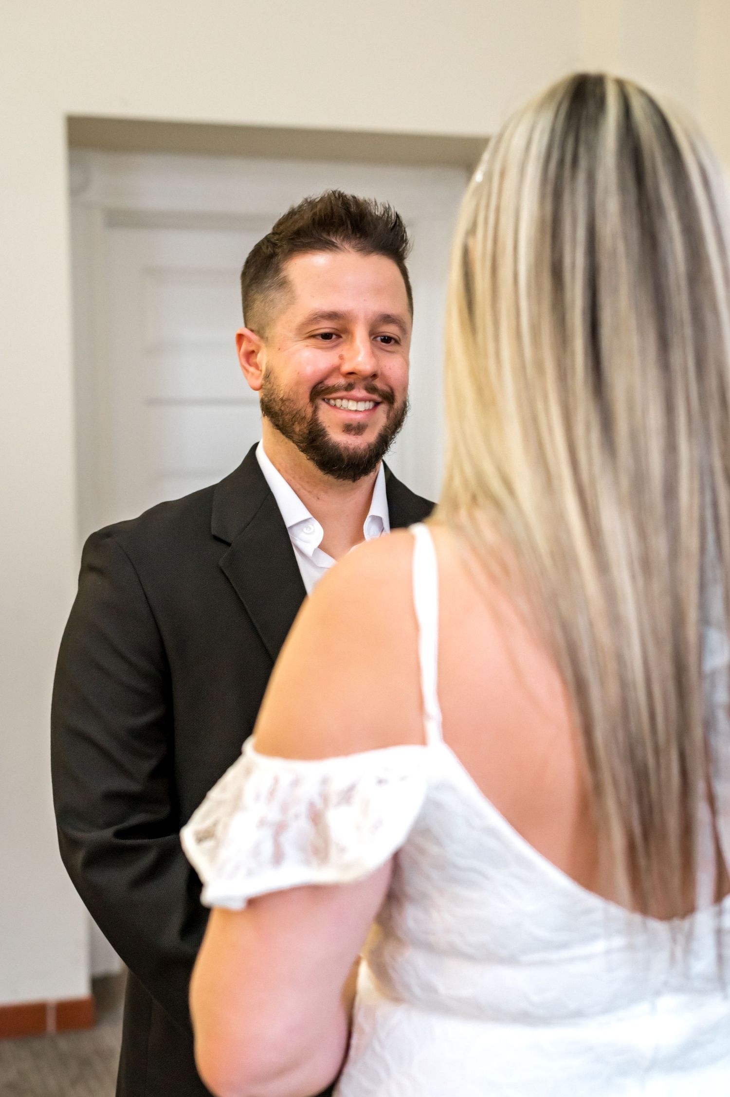 A couple exchanges loving glances during their indoor wedding ceremony.