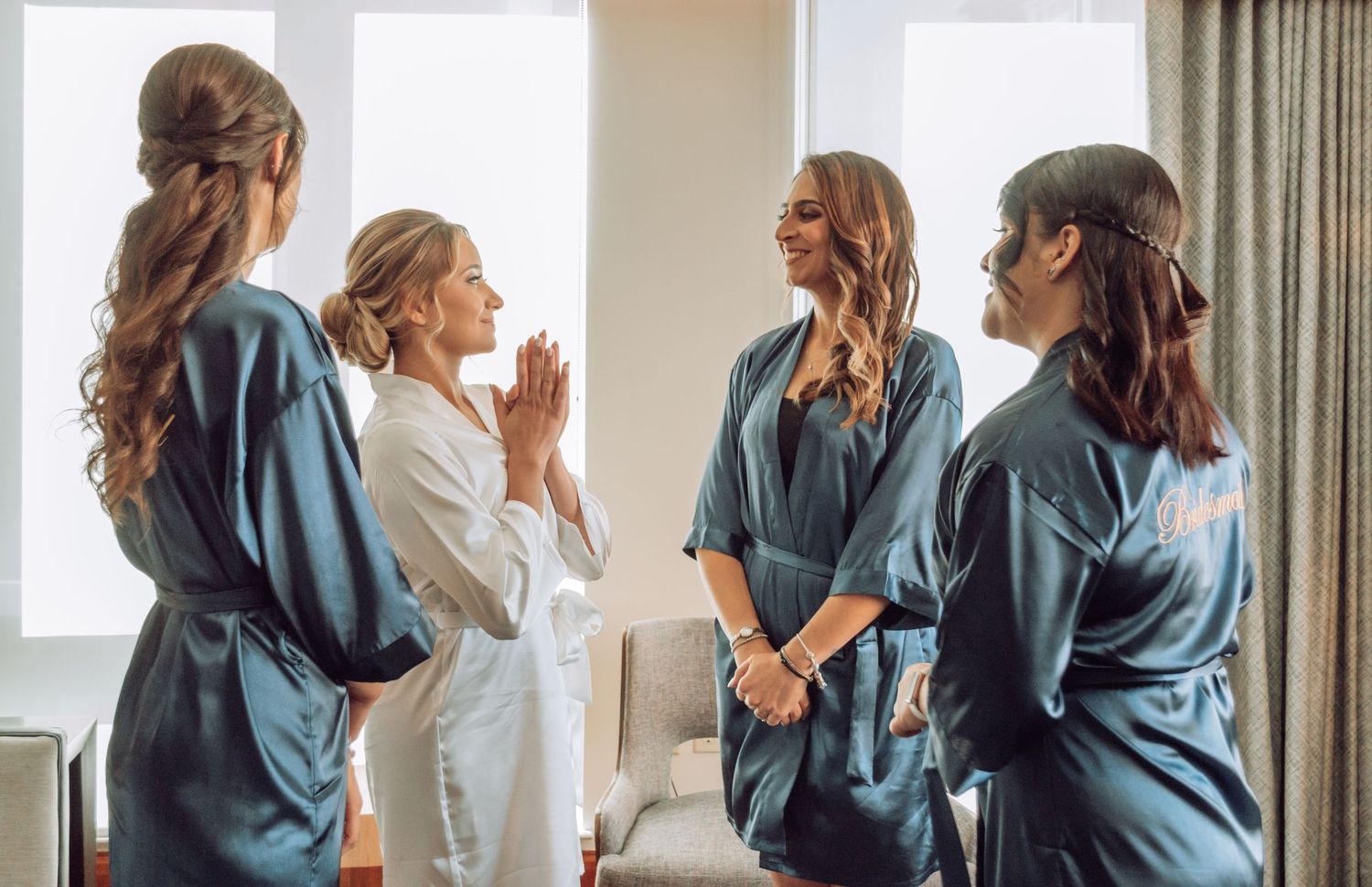 Group wearing matching blue robes gather together in candid photo sequence near window.