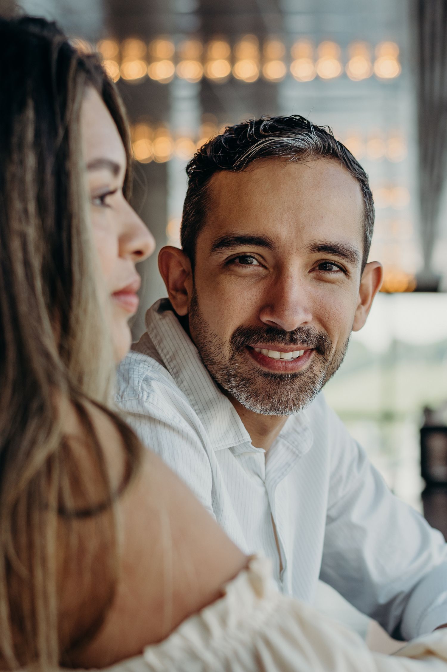 A couple in close intimacy sharing a tender moment with bokeh lights in the background.