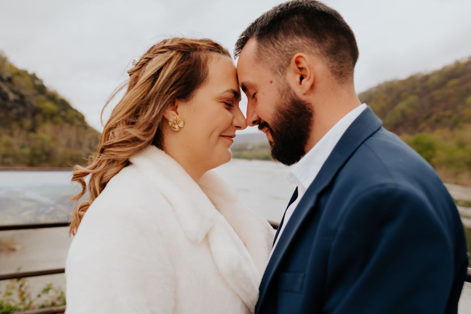 A romantic couple embraces while sharing tender moments during their mountain vista wedding photo session at sunset.