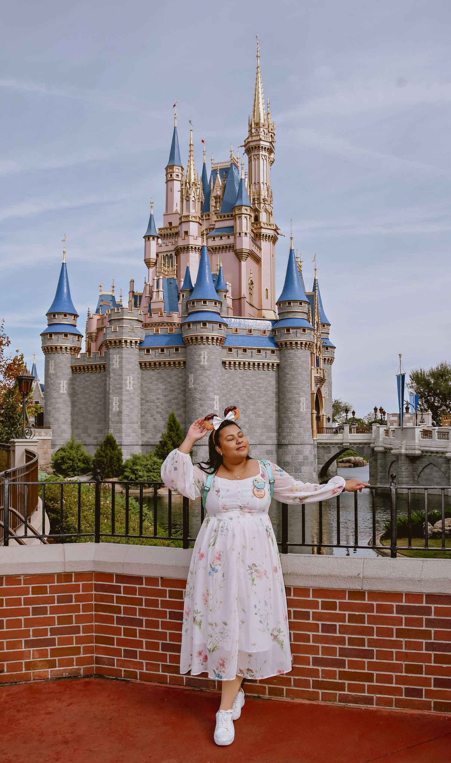 Beautiful white castle with blue spires at Disney World Magic Kingdom towering against a bright blue sky.